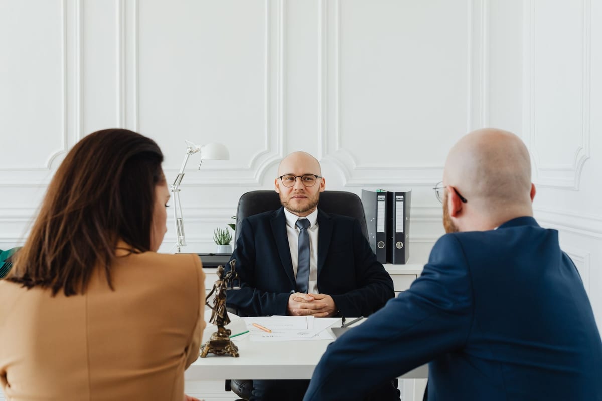 Two clients receiving advice from a lawyer across a desk